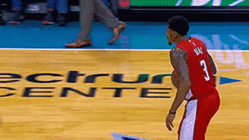 A Man In A Red Jersey With The Number 3 On It Stands On A Basketball Court GIF