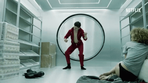 A Man In A Red Jumpsuit Is Dancing In A Room With A Netflix Logo GIF