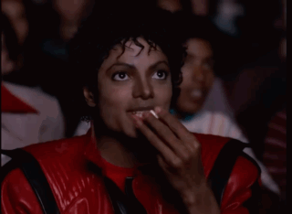 A Man In A Red Leather Jacket Is Covering His Mouth With His Hands GIF