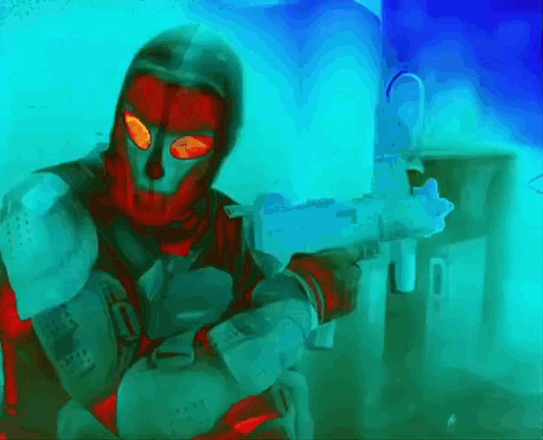 a man in a red mask is holding a gun in front of a blue wall