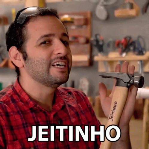 A Man In A Red Plaid Shirt Is Holding A Hammer With The Word Jeitinho Written On It GIF