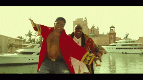 A Man In A Red Robe Is Dancing With Another Man In A Gold Robe GIF