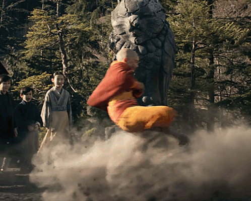 A Man In A Red Robe Is Flying Through The Air In Front Of A Statue GIF