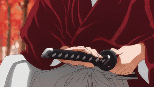 A Man In A Red Robe Is Holding A Sword In His Hands GIF