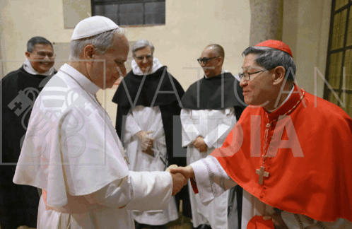A Man In A Red Robe Is Shaking Hands With Another Man In A White Robe GIF