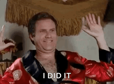 A Man In A Red Robe Is Waving His Hands In The Air And Smiling . GIF