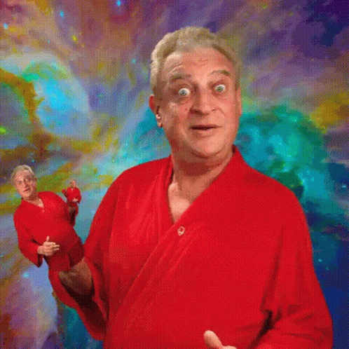 A Man In A Red Robe Stands In Front Of A Colorful Background . GIF