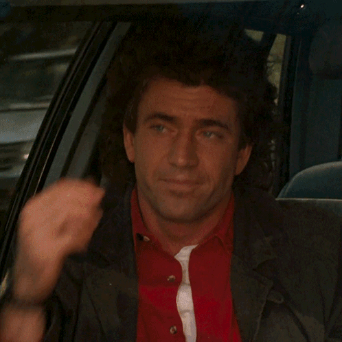 a man in a red shirt and black jacket is sitting in the back seat of a car