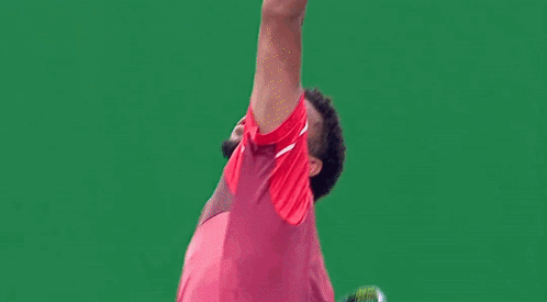 a man in a red shirt and shorts is playing tennis