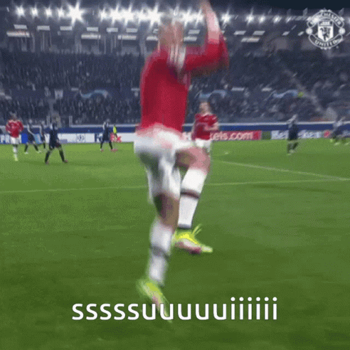 A Man In A Red Shirt And White Shorts Is Jumping In The Air On A Soccer Field GIF