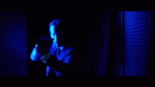 a man in a red shirt is being punched in the face by another man in a suit