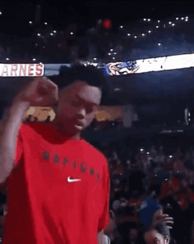 a man in a red shirt is dancing in front of a crowd with a sign that says big