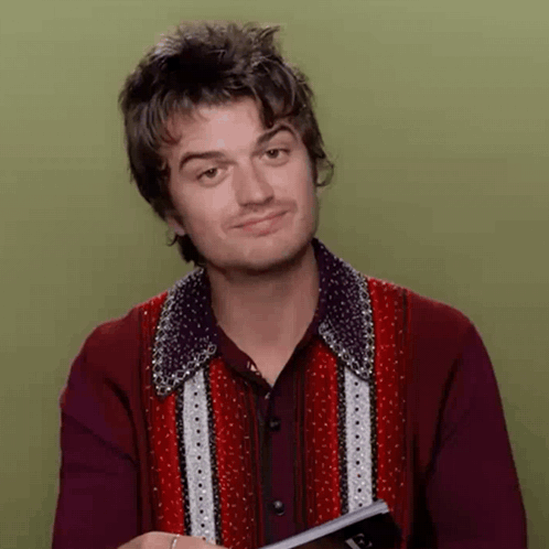 A Man In A Red Shirt Is Holding A Book And Making A Funny Face GIF