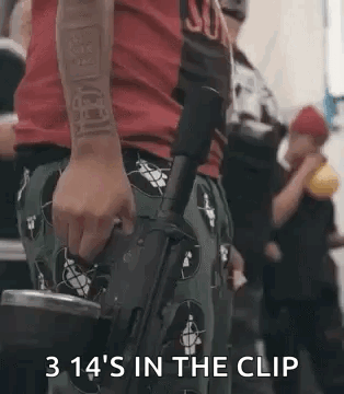 A Man In A Red Shirt Is Holding A Gun In His Hand And Says `` 3 14 'S In The Clip '' . GIF