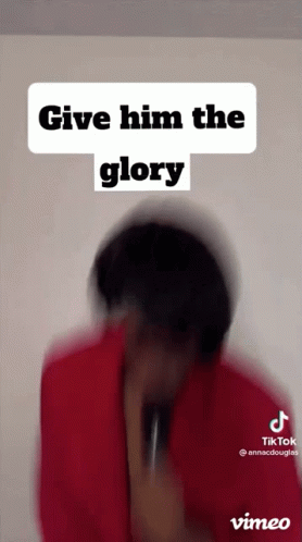 A Man In A Red Shirt Is Holding A Microphone And Says Give Him The Glory . GIF