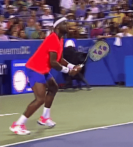 a man in a red shirt is holding a tennis racquet on a court