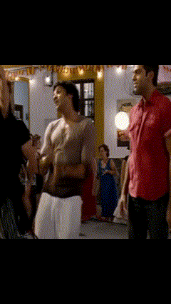 A Man In A Red Shirt Is Holding A Woman In A Room GIF