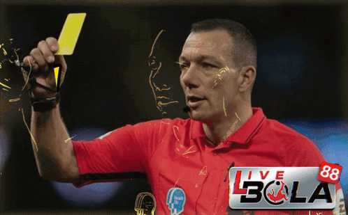 A Man In A Red Shirt Is Holding A Yellow Card In Front Of A Banner That Says Live Bola GIF