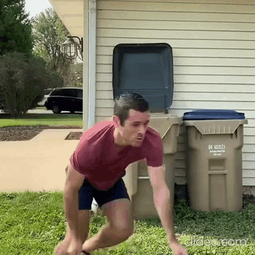 A Man In A Red Shirt Is Jumping In Front Of A Trash Can With The Number 04 On It .. GIF
