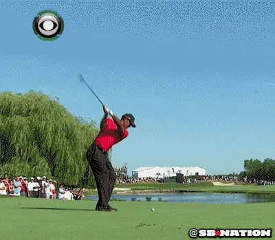 A Man In A Red Shirt Is Kneeling Down On A Golf Course With A Cbs Logo In The Background GIF
