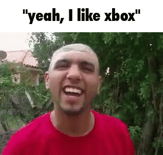 A Man In A Red Shirt Is Laughing While Standing In Front Of Trees . GIF