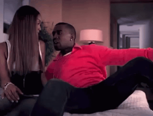 Man In Red Shirt Laying On Bed With Woman GIF