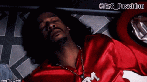 A Man In A Red Shirt Is Laying On The Floor With His Eyes Closed GIF