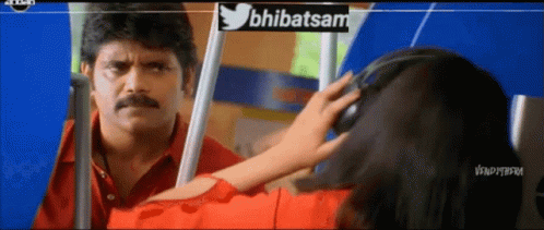 A Man In A Red Shirt Is Looking At A Woman In A Red Shirt With Headphones On GIF