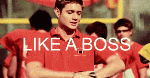 A Man In A Red Shirt Is Looking At His Watch With The Words Like A Boss Above Him . GIF