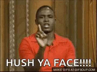 A Man In A Red Shirt Is Making A Funny Face And Pointing At The Camera . GIF