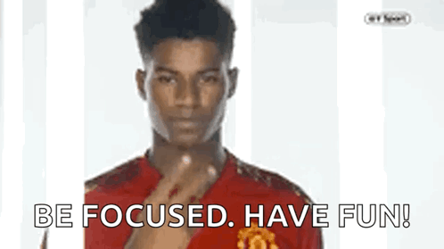 A Man In A Red Shirt Is Pointing At The Camera With The Words Be Focused Have Fun Below Him GIF