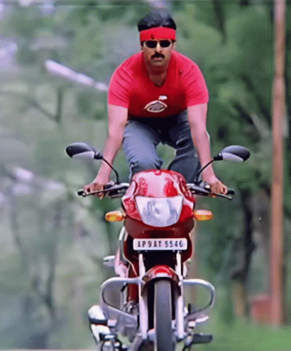 A Man In A Red Shirt Is Riding A Motorcycle With A License Plate That Says Ap9at 5556 GIF
