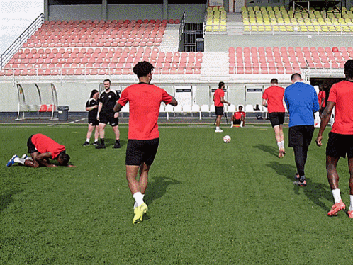 A Man In A Red Shirt Is Running On A Field GIF
