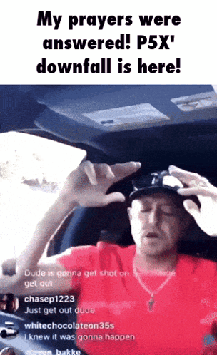 a man in a red shirt is sitting in the driver 's seat of a car