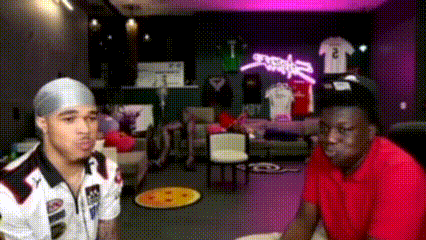 a man in a red shirt is sitting next to another man in a white shirt