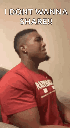 A Man In A Red Shirt Is Sitting On A Couch And Says `` I Dont Wanna Share '' . GIF