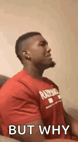 A Man In A Red Shirt Is Sitting On A Couch And Talking To Someone . GIF