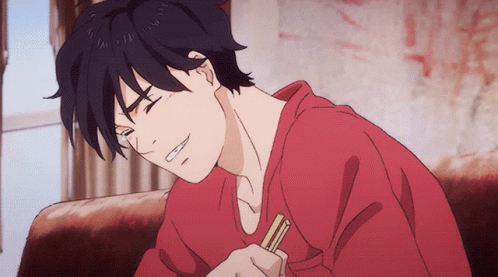 A Man In A Red Shirt Is Sitting On A Couch Holding Chopsticks GIF