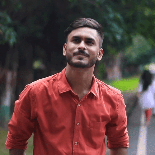 A Man In A Red Shirt Is Smiling And Looking Up GIF
