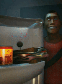 A Man In A Red Shirt Is Smiling In Front Of A Fridge GIF