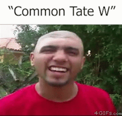 A Man In A Red Shirt Is Smiling With The Words `` Common Tate W '' Written Above Him . GIF