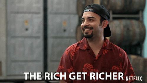 A Man In A Red Shirt Is Smiling With The Words The Rich Get Richer Netflix Below Him GIF