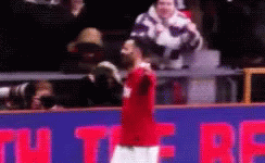 A Man In A Red Shirt Is Standing In Front Of A Sign That Says ' U ' On It GIF