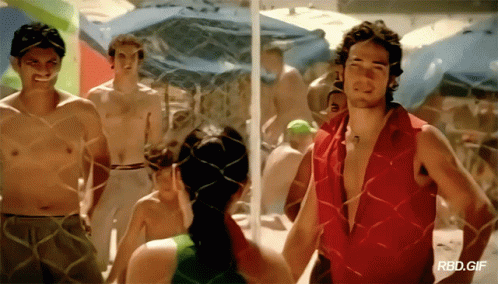 A Man In A Red Shirt Is Standing Next To A Woman In A Green Tank Top GIF