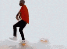 A Man In A Red Shirt Is Standing On A Pile Of Ice GIF