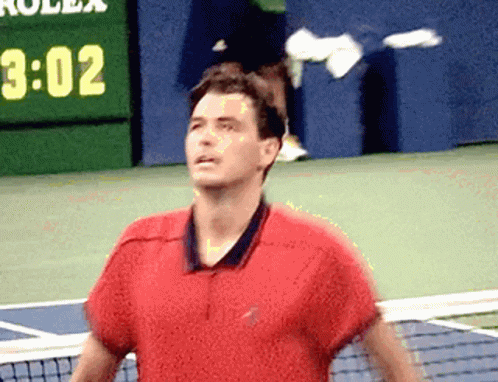 A Man In A Red Shirt Is Standing On A Tennis Court In Front Of A Scoreboard That Says 3:02 GIF