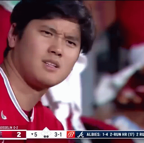 A Man In A Red Shirt Is Watching A Baseball Game GIF