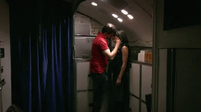 A Man In A Red Shirt Kisses A Woman In A Kitchen GIF