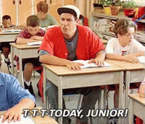 A Man In A Red Shirt Sits At A Desk In A Classroom With The Words T-T-T-Today Junior GIF
