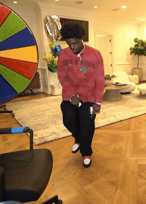 A Man In A Red Shirt That Says Guns N Roses Is Dancing GIF